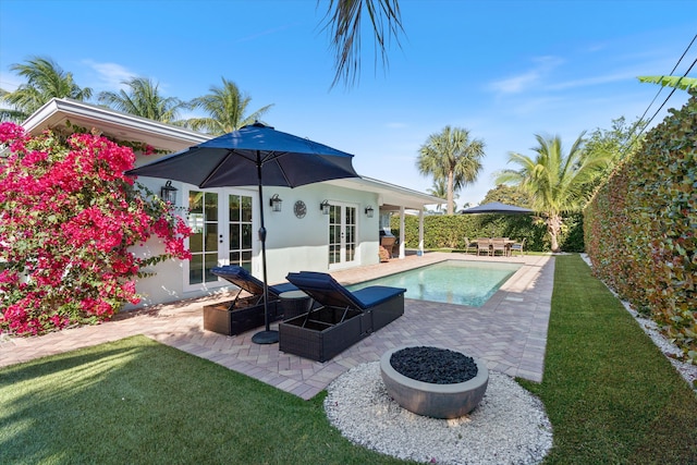 outdoor pool featuring a patio area, a lawn, and french doors