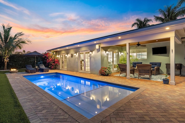 view of pool featuring a ceiling fan, a fenced in pool, french doors, a patio area, and an outdoor hangout area