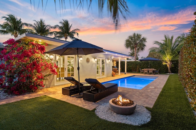 view of pool featuring a patio, french doors, and a lawn