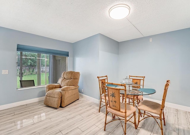 dining area with a textured ceiling, wood finish floors, and baseboards