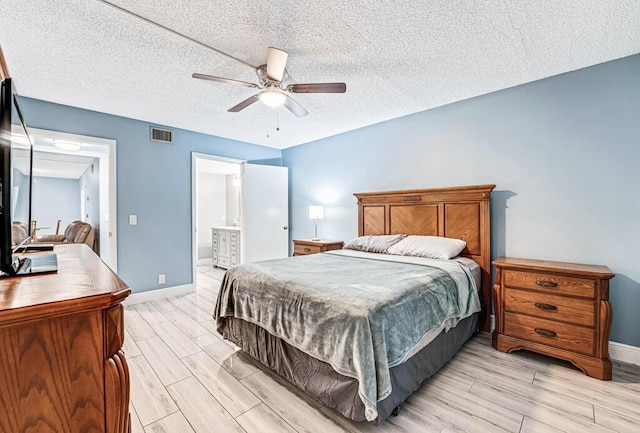 bedroom with a textured ceiling, wood finish floors, a ceiling fan, visible vents, and baseboards