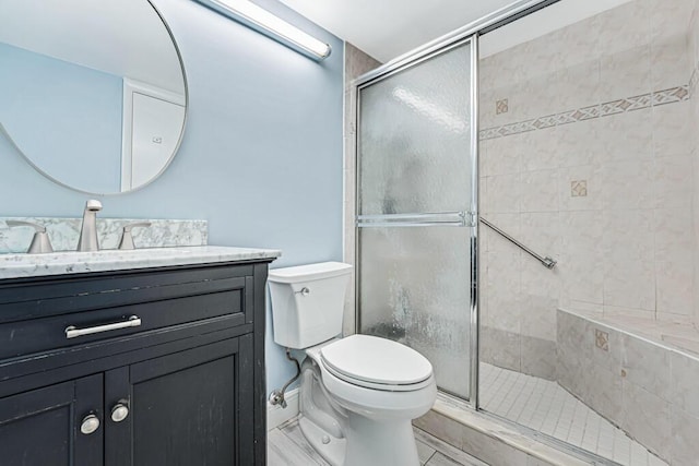 bathroom featuring a stall shower, vanity, and toilet