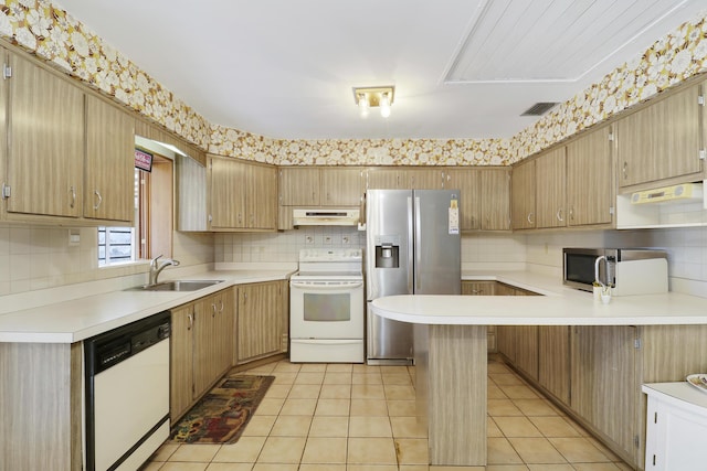 kitchen with light countertops, appliances with stainless steel finishes, light tile patterned flooring, a sink, and under cabinet range hood