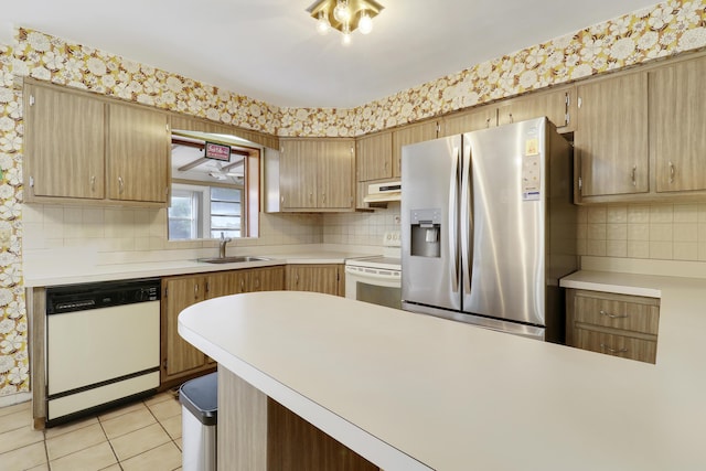 kitchen featuring white appliances, light countertops, and under cabinet range hood