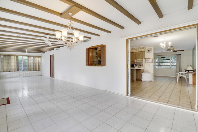 unfurnished living room with ceiling fan with notable chandelier, beam ceiling, light tile patterned flooring, and a wealth of natural light