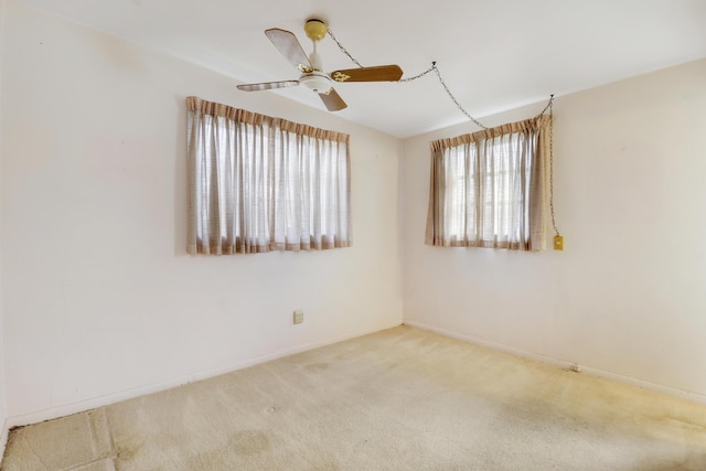 spare room featuring carpet floors, baseboards, and a ceiling fan