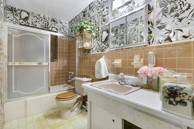 full bath with tile walls, tasteful backsplash, toilet, enclosed tub / shower combo, and vanity