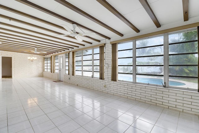 unfurnished room featuring light tile patterned floors, brick wall, beam ceiling, and ceiling fan with notable chandelier