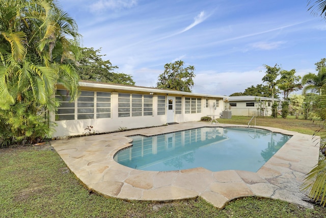 view of swimming pool featuring a lawn and a fenced in pool