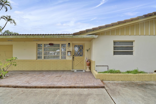 entrance to property featuring a patio and stucco siding