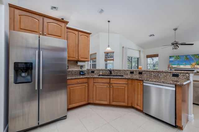 kitchen with visible vents, a sink, dark stone counters, appliances with stainless steel finishes, and brown cabinetry