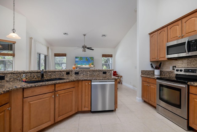 kitchen featuring visible vents, dark stone countertops, stainless steel appliances, and lofted ceiling