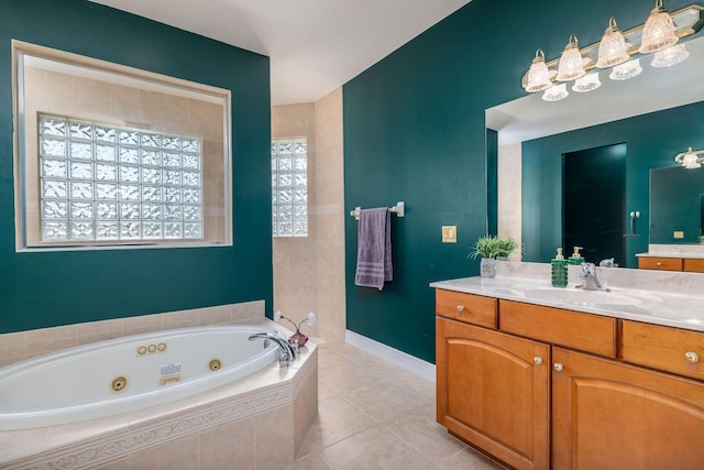 full bath with tile patterned floors, a tub with jets, vanity, and baseboards