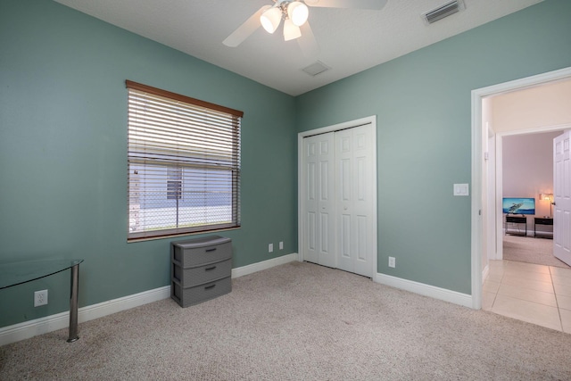 tiled bedroom with baseboards, visible vents, carpet floors, ceiling fan, and a closet