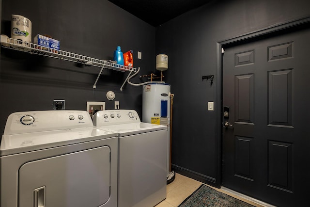 laundry area with light tile patterned floors, baseboards, laundry area, electric water heater, and washer and dryer