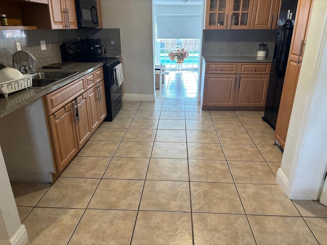 7430 Atlanta St, Hollywood, FL 33024 - kitchen featuring dark countertops, black appliances, light tile patterned floors, and a sink