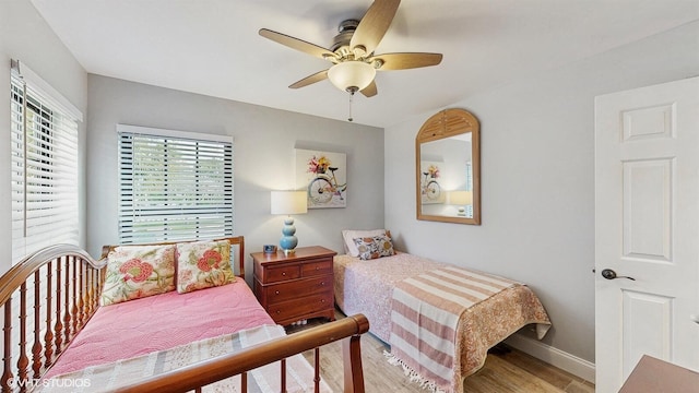 bedroom with light wood-type flooring, ceiling fan, and baseboards