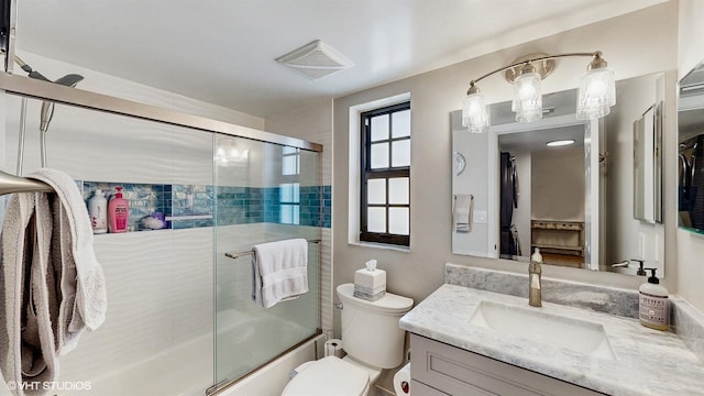 bathroom with enclosed tub / shower combo, toilet, vanity, and visible vents