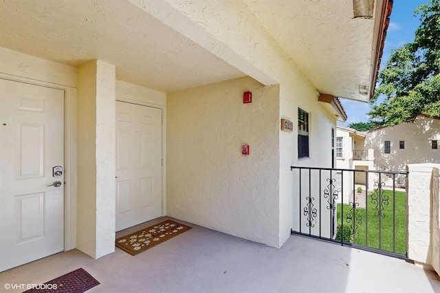 doorway to property featuring a balcony and stucco siding