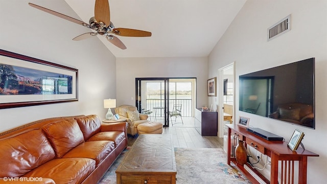 living room featuring lofted ceiling, visible vents, ceiling fan, and light wood finished floors