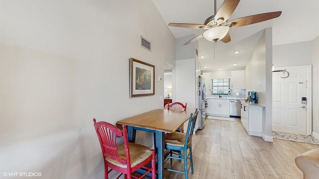 dining room with light wood-style flooring, visible vents, and a ceiling fan