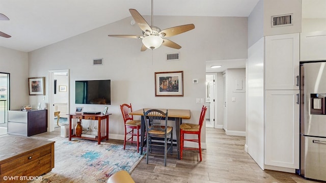 dining room with light wood finished floors, visible vents, and a ceiling fan