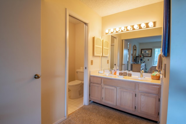 full bath with a sink, a textured ceiling, toilet, and double vanity