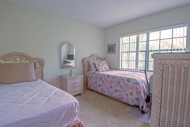 bedroom featuring light colored carpet and a textured ceiling