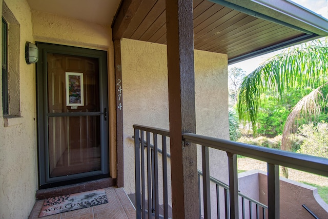 doorway to property with a balcony and stucco siding