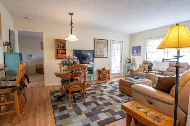 living room featuring dark wood-style floors, baseboards, and a textured ceiling