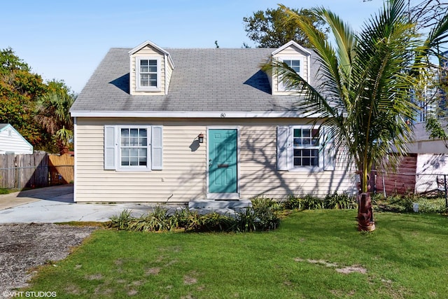 cape cod-style house featuring entry steps, fence, and a front yard