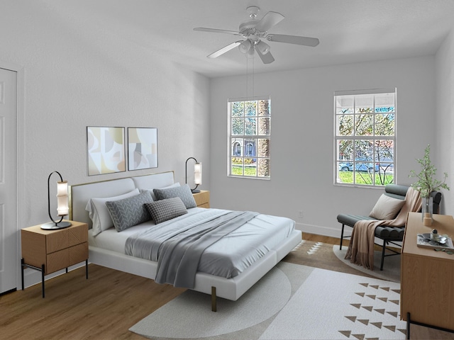 bedroom with multiple windows, ceiling fan, baseboards, and wood finished floors