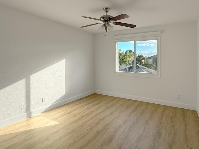 unfurnished room featuring light wood-style floors, baseboards, and a ceiling fan