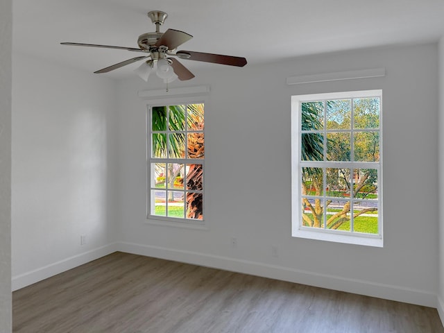 empty room with a ceiling fan, baseboards, and wood finished floors