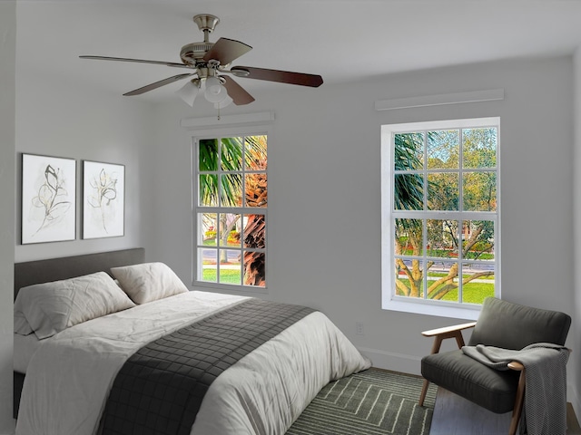 bedroom with multiple windows, baseboards, and a ceiling fan