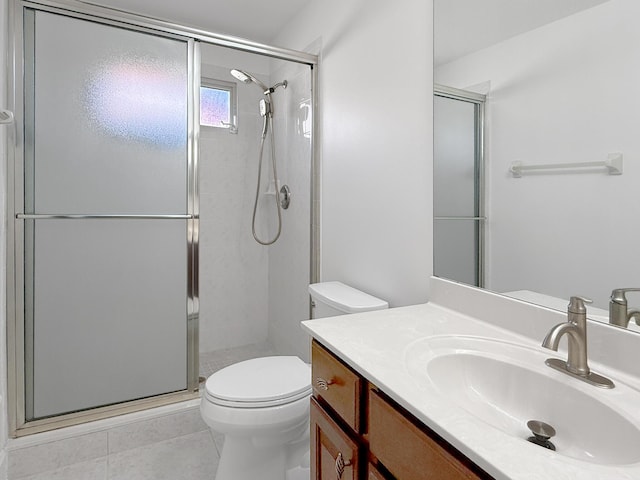 bathroom with toilet, tile patterned flooring, vanity, and a shower with shower door