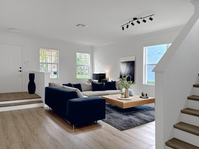 living area featuring crown molding, stairs, visible vents, and wood finished floors