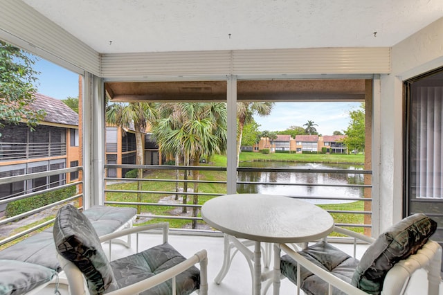 sunroom featuring a water view