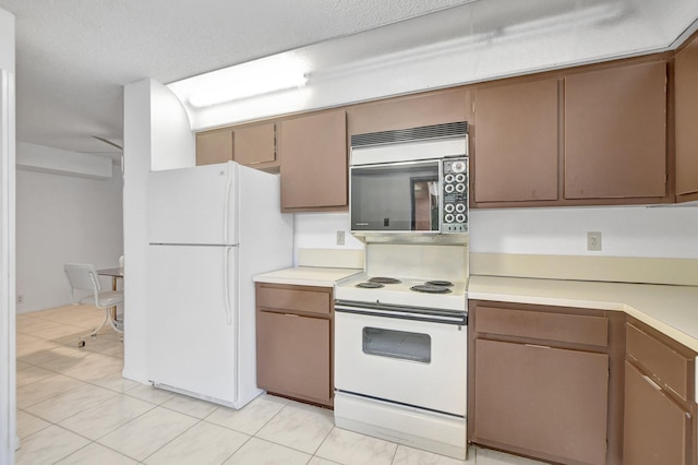 kitchen with white appliances, light tile patterned floors, and light countertops