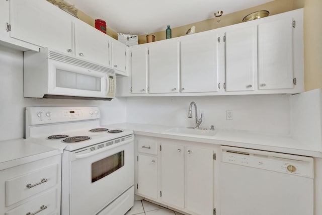 kitchen featuring light tile patterned floors, white appliances, a sink, white cabinets, and light countertops