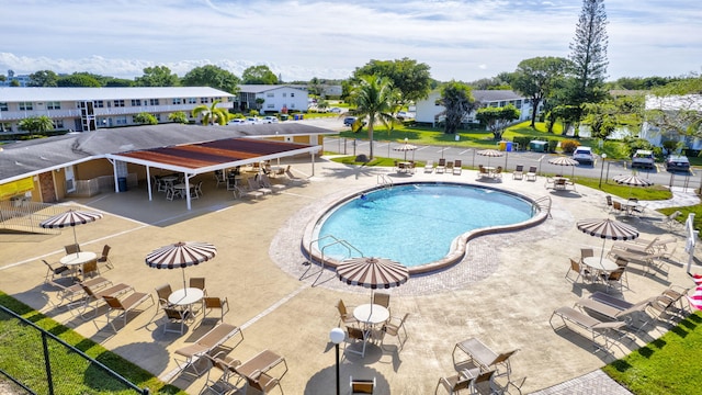 community pool featuring a residential view, a patio area, and fence