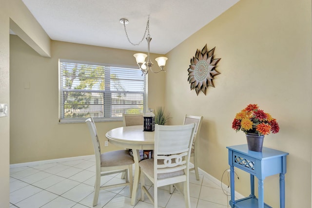 dining space featuring light tile patterned floors, baseboards, and an inviting chandelier