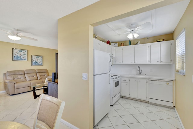 kitchen with light countertops, open floor plan, white cabinets, a sink, and white appliances