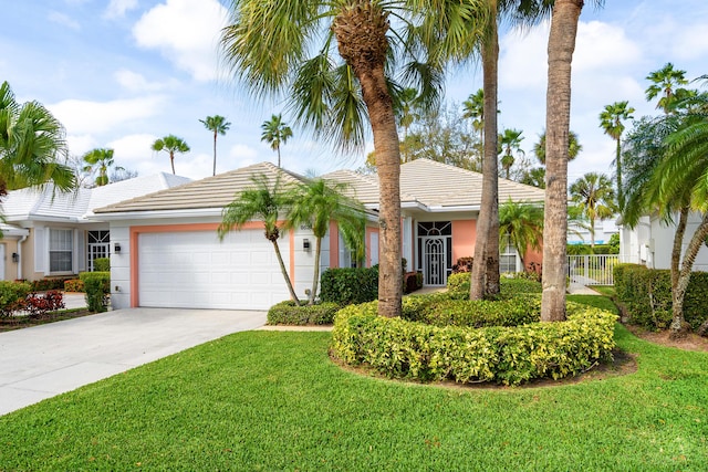 single story home featuring an attached garage, concrete driveway, a tiled roof, stucco siding, and a front lawn