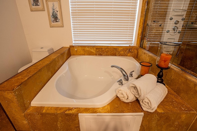 full bathroom featuring toilet and a bath