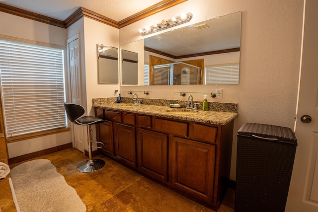 bathroom with ornamental molding, a sink, a shower stall, and double vanity