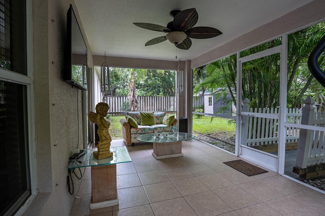 unfurnished sunroom featuring ceiling fan