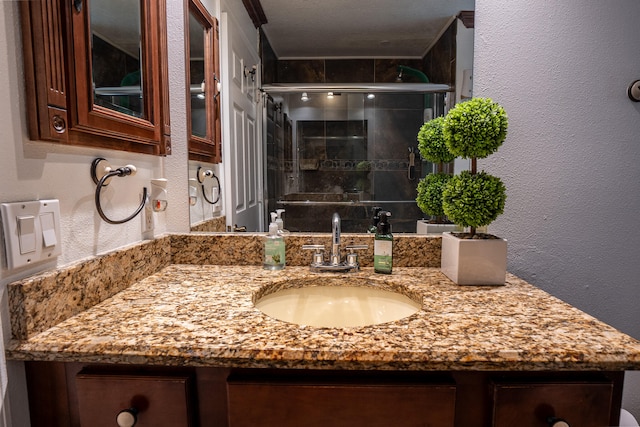 bathroom featuring a textured wall and vanity