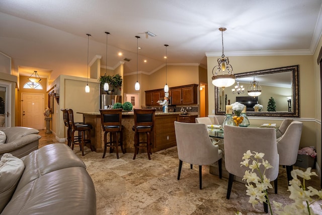 dining space featuring high vaulted ceiling and crown molding