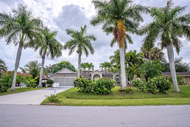 view of front of home featuring driveway, a garage, and a front yard